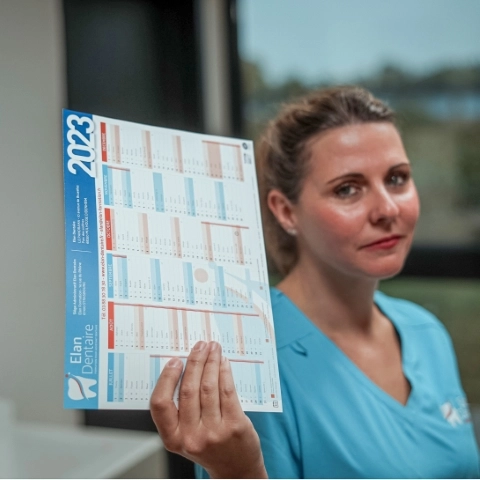 Photographie de Nathalie, responsable pédagogique chez ELAN Dentaire, montrant un calendrier